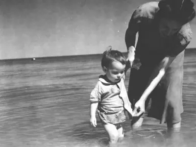 mother guiding baby in the water