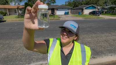 Woman Holding Up Water Test Sample