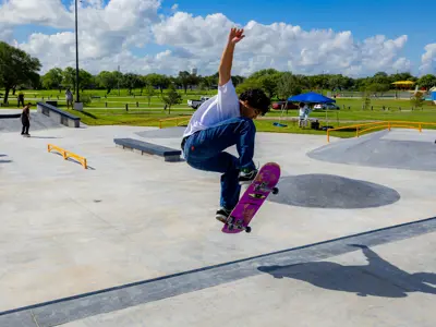 Boy doing a skateboarding trick at West Guth Park