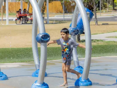 Boy running through the splash pad