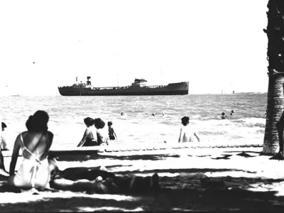 people watching a ship from the shore